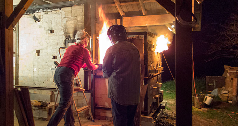 stoking the wood kiln